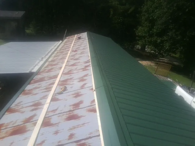 Old rusted panels beside newly installed green metal roofing — Wind Damage Roof Repair by Roofing Brothers in Sherwood