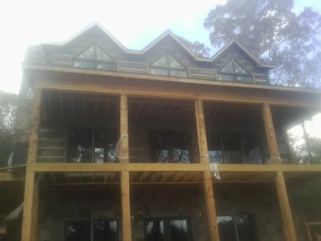 Dormers and porch framing on a large log home under construction — Roof Coating work by our crew in Sherwood